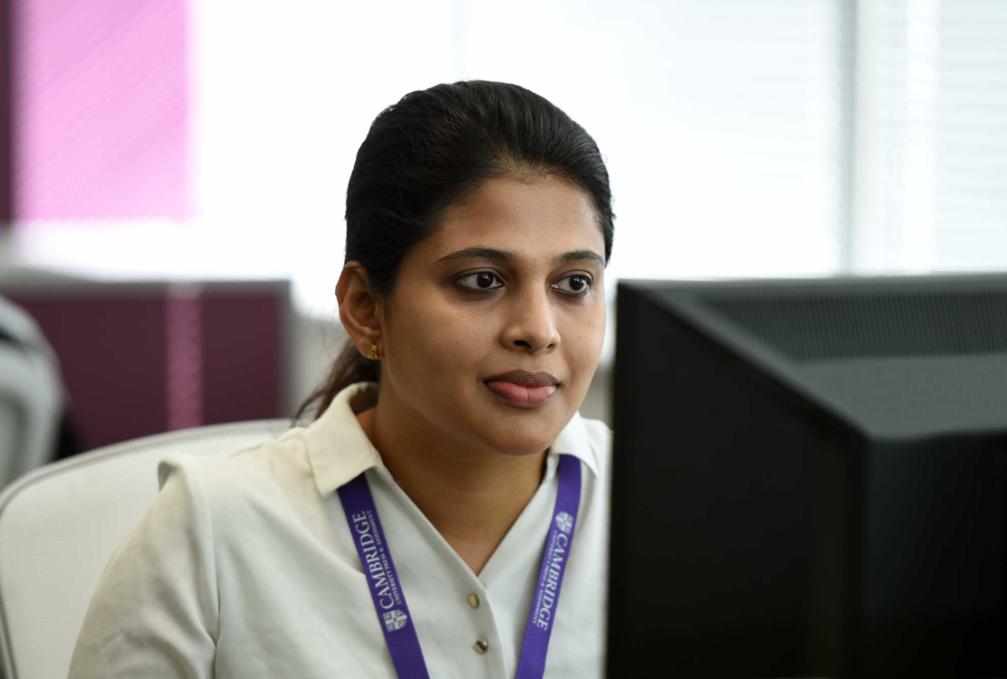 A female Cambridge colleague working at her computer.