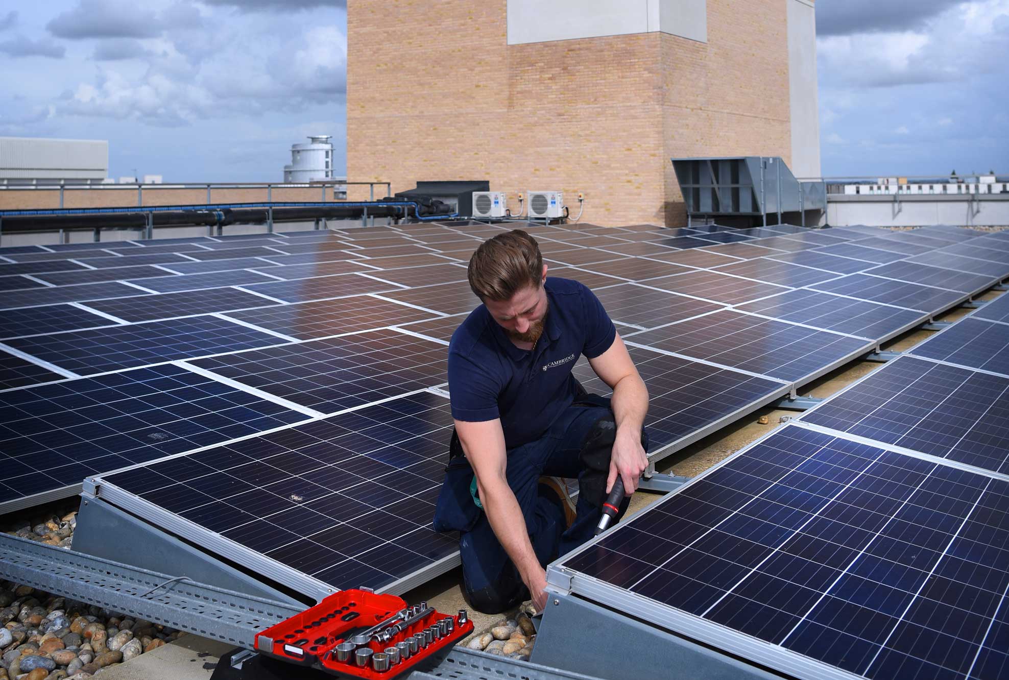 An engineer fitting solar panels to the roof of our offices in Cambridge.