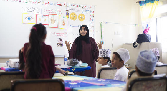 Teacher in Omani classroom engaging with class