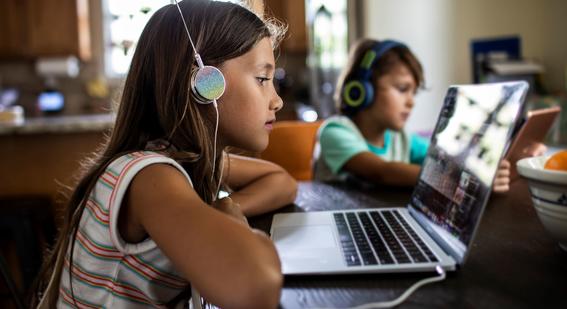 girl with headphones watching on laptop