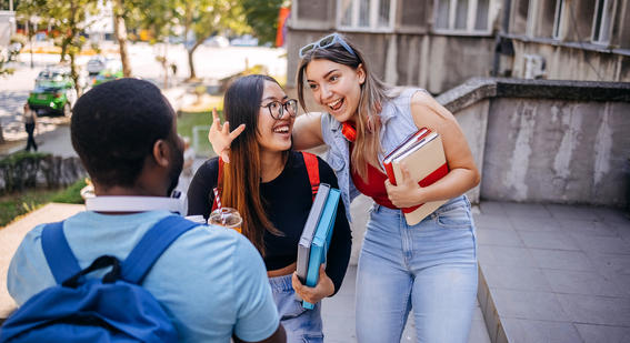 Group of university students chatting outside the teaching building after class