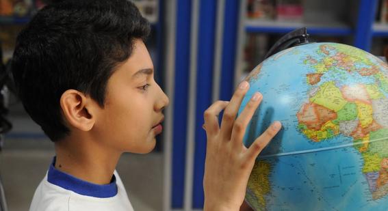 A boy pointing at a globe model