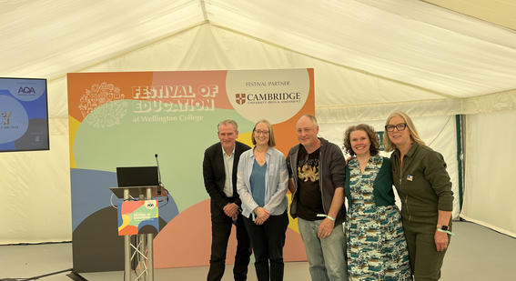 5 colleagues stand posing for a photo before going on stage at Festival of Education