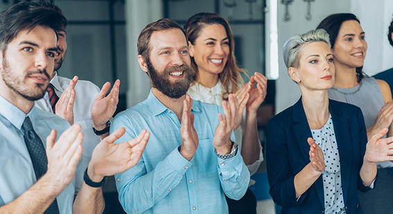 seven colleagues standing up and applauding