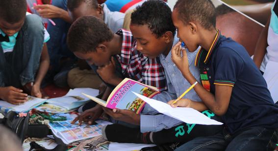 Children reading books and filling out activity books