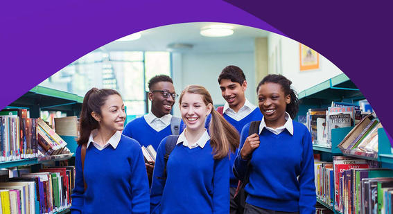 five teenage students walking through a library