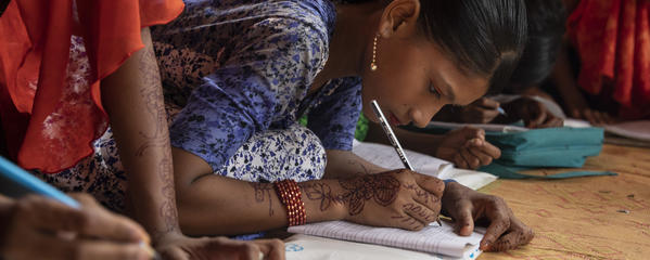 Girls learning and writing in a refugee camp